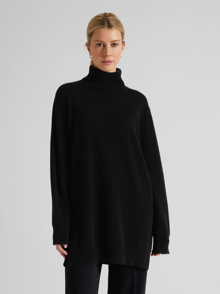 Long polo sweater in 100% pure cashmere. Scandinavian design by Kashmina. Color: Black.
