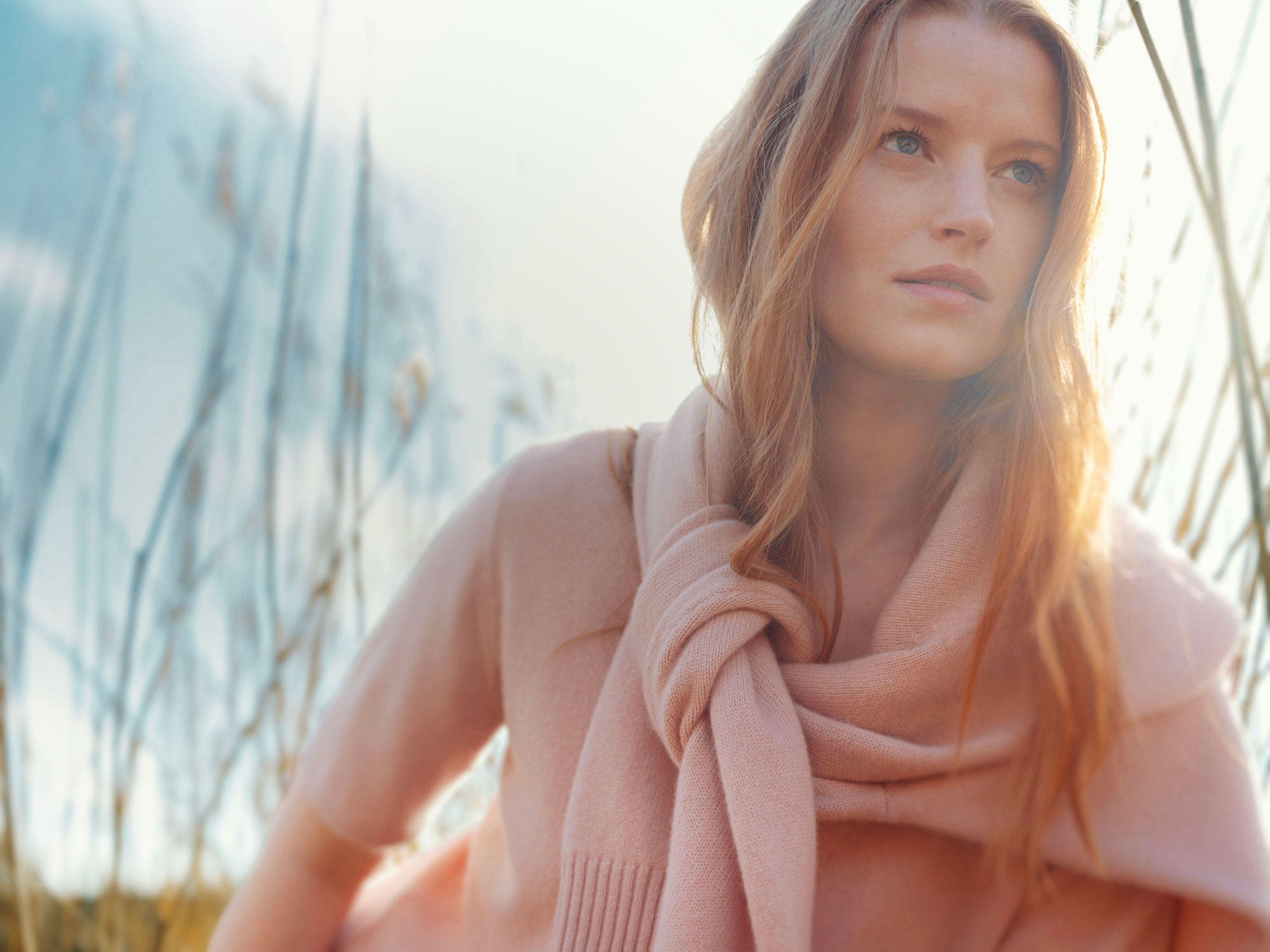 Woman wearing a pink scarf with a blurred natural background